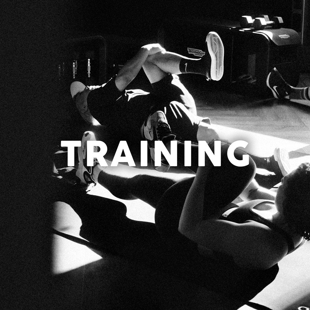 Group fitness training indoors on a mat.