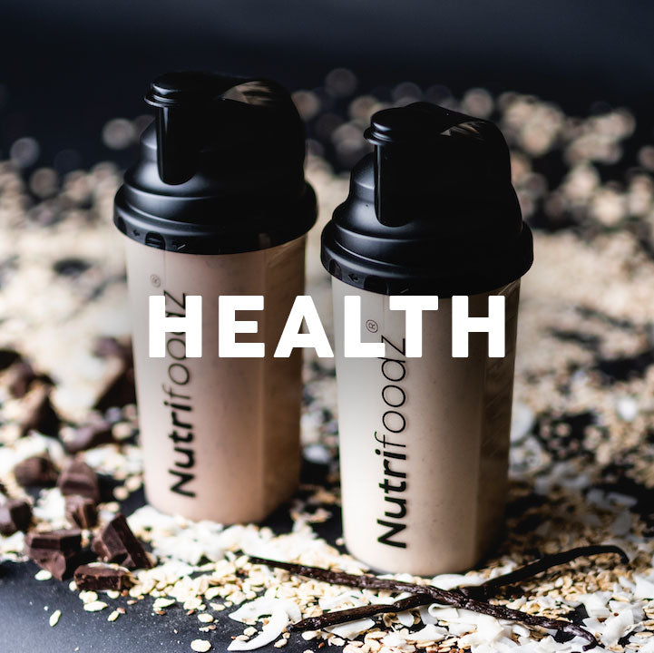 Two Nutrifoodz shakers with raw ingredients, cacao, vanilla pods, and oats.